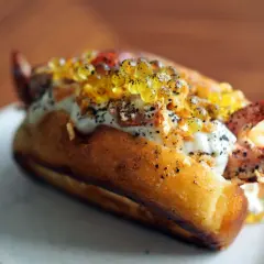 Un delicioso lobster roll receta, con carne de cangrejo, caviar y salsa cremosa en un pan tostado.