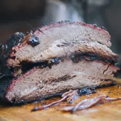 Brisket ahumado, jugoso y tierno, con una corteza oscura y deliciosa. Perfecto para una barbacoa.