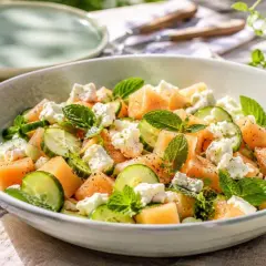 Refrescante ensalada de melón con pepino, queso feta y menta, perfecta para un día soleado.
