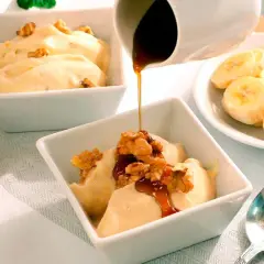 Disfruta de hacer helado casero con esta deliciosa receta de banana y nueces, cubierta con sirope.