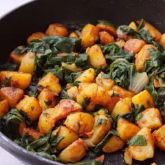 Acelgas con patatas doradas y tiernas, cocinadas en sartén. Un plato casero lleno de sabor y color.