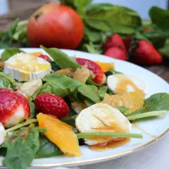Deliciosa ensalada de espinacas con fresas, naranja, queso de cabra y nueces, bañada en aderezo dulce.