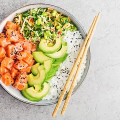 Un delicioso poke de salmón con aguacate, arroz blanco y vegetales frescos.