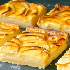 Porciones de tarta de manzana con crema pastelera, cubiertas con un glaseado brillante y rodajas de manzana caramelizadas.