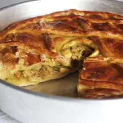 Empanada de carne dorada y crujiente, con un relleno jugoso visible en un corte. Perfecta para compartir.