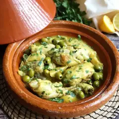 Tajín de pollo con aceitunas verdes y limón, servido en una cazuela de barro tradicional.