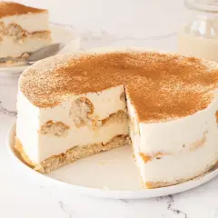 Tarta de horchata y fartons, con bizcocho y crema, espolvoreada con canela. Una porción ya servida.