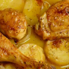 Pollo al horno dorado y jugoso, con patatas y cebolla, todo bañado en su propio jugo. ¡Un festín para la vista y el paladar!