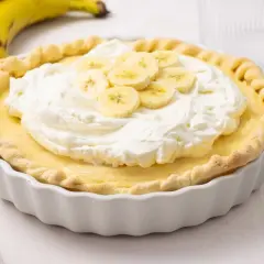 Deliciosa tarta de plátano con crema batida y rodajas de plátano fresco.