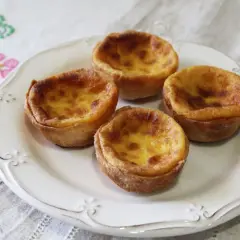 Cuatro pastelitos de arroz dorados y cremosos en un plato blanco, listos para ser disfrutados.