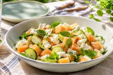 Refrescante ensalada de melón con pepino, queso feta y menta, perfecta para un día soleado.