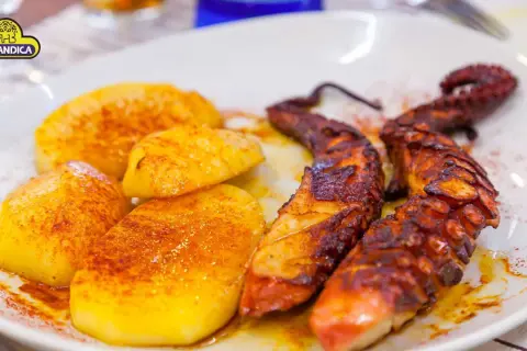 Pulpo a la gallega con patatas cocidas y pimentón. Un plato tradicional español listo para disfrutar.