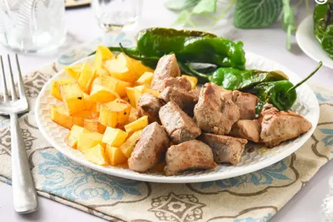 Raxo con patatas y pimientos de Padrón, un plato gallego delicioso y sencillo.