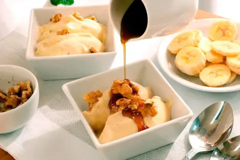Disfruta de hacer helado casero con esta deliciosa receta de banana y nueces, cubierta con sirope.