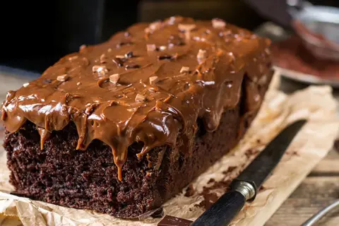 Bizcocho de chocolate casero con glaseado de chocolate derretido y trocitos de chocolate. ¡Una delicia irresistible!