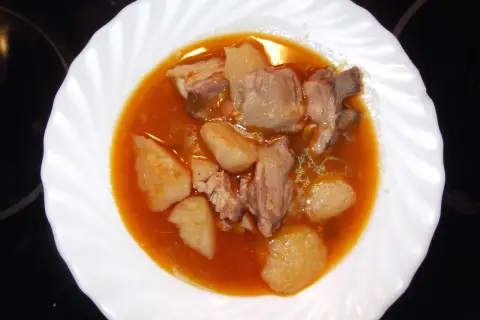 Plato de patatas con costillas en salsa roja. Un guiso casero que reconforta el alma.