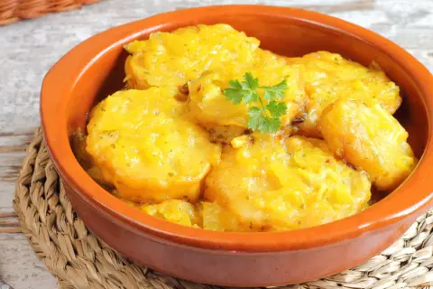 Patatas a la importancia, un plato reconfortante y delicioso, servido en cazuela de barro con perejil fresco.