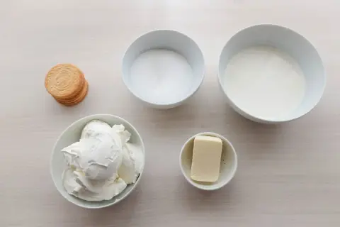 Ingredientes para tarta de queso sin horno: queso crema, azúcar, nata, mantequilla y galletas.