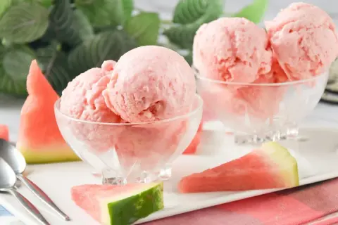 Delicioso helado de sandía en copas de cristal, acompañado de trozos de sandía fresca y cucharas.