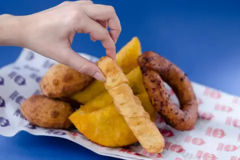 Mano toma un tequeño, un bocado delicioso que nos recuerda de donde son los tequeños, junto a empanadas y chorizo.