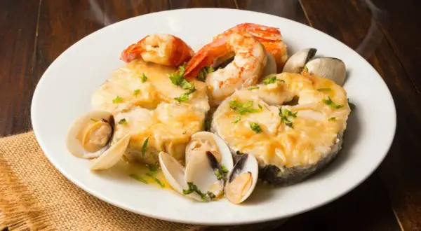 Merluza a la marinera con gambas y almejas, un plato delicioso y aromático.