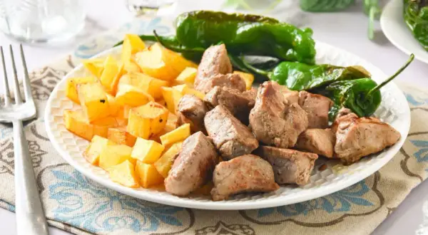 Raxo con patatas y pimientos de Padrón, un plato gallego delicioso y sencillo.