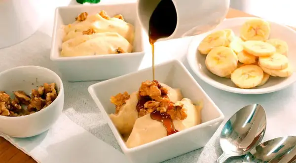 Disfruta de hacer helado casero con esta deliciosa receta de banana y nueces, cubierta con sirope.