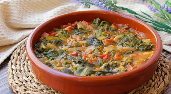 Un plato humeante de acelgas guisadas con tomate y cebolla, perfecto para tus recetas con acelgas.