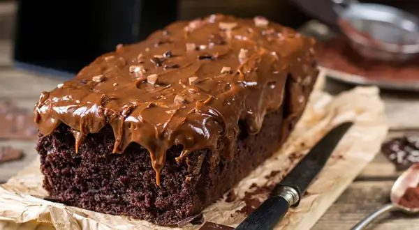 Bizcocho de chocolate casero con glaseado de chocolate derretido y trocitos de chocolate. ¡Una delicia irresistible!