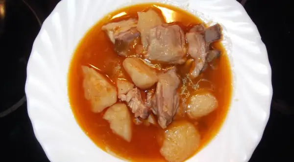 Plato de patatas con costillas en salsa roja. Un guiso casero que reconforta el alma.