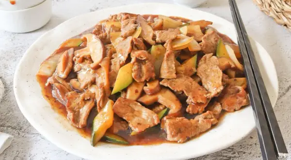 Ternera salteada con champiñones y calabacín en una rica salsa de ostras, lista para disfrutar con palillos.