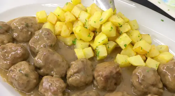 Albóndigas en salsa arguiñano, jugosas y tiernas, acompañadas de patatas fritas doradas y perejil picado. ¡Un plato casero irresistible!