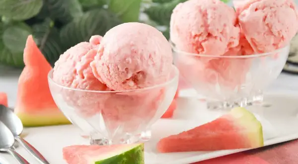 Delicioso helado de sandía en copas de cristal, acompañado de trozos de sandía fresca y cucharas.