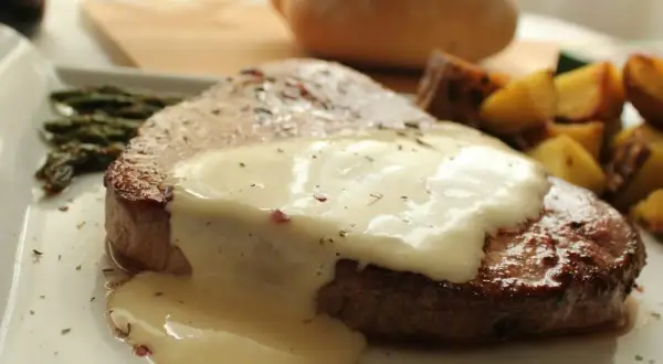 Un jugoso corte redondo en salsa cremosa, acompañado de espárragos y patatas asadas.