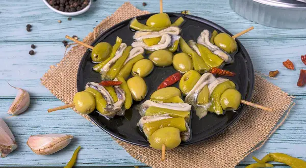 Brochetas de aceitunas, pimientos y anchoas, un picoteo fácil y rápido.