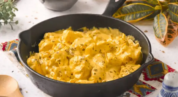 Sabroso pollo al curry con leche de coco, servido en sartén de hierro fundido.