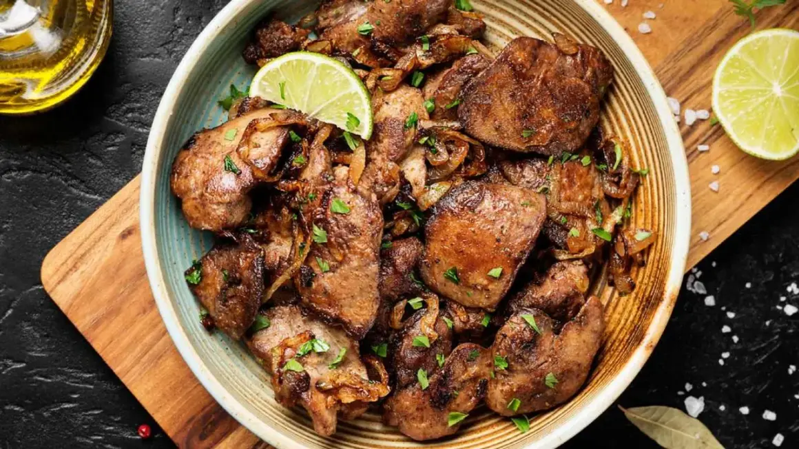 Sabrosos higaditos de pollo encebollados, salpicados de perejil fresco y adornados con rodajas de lima. Un plato casero irresistible.