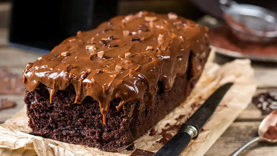 Bizcocho de chocolate casero con glaseado de chocolate derretido y trocitos de chocolate. ¡Una delicia irresistible!