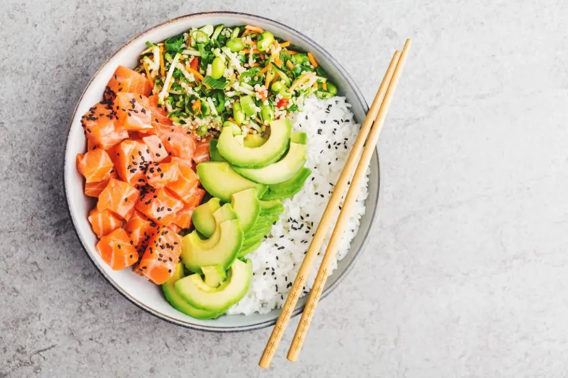 Un delicioso poke de salmón con aguacate, arroz blanco y vegetales frescos.