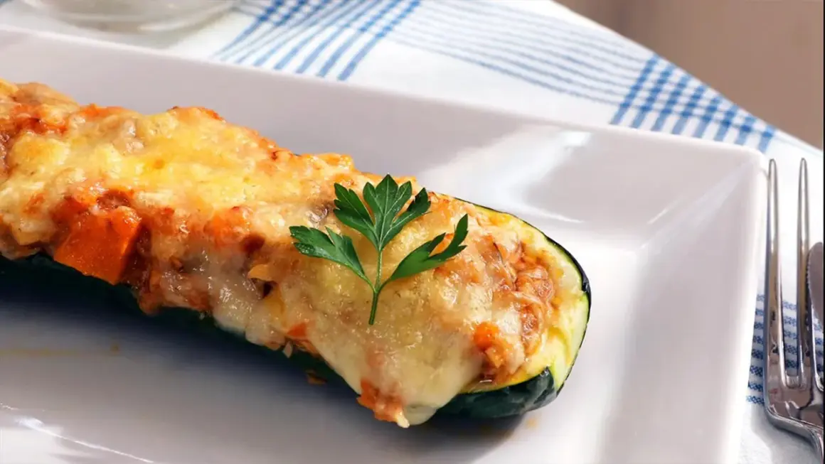 Calabacines rellenos de atún, gratinados con queso y decorados con perejil. Un plato delicioso y saludable.