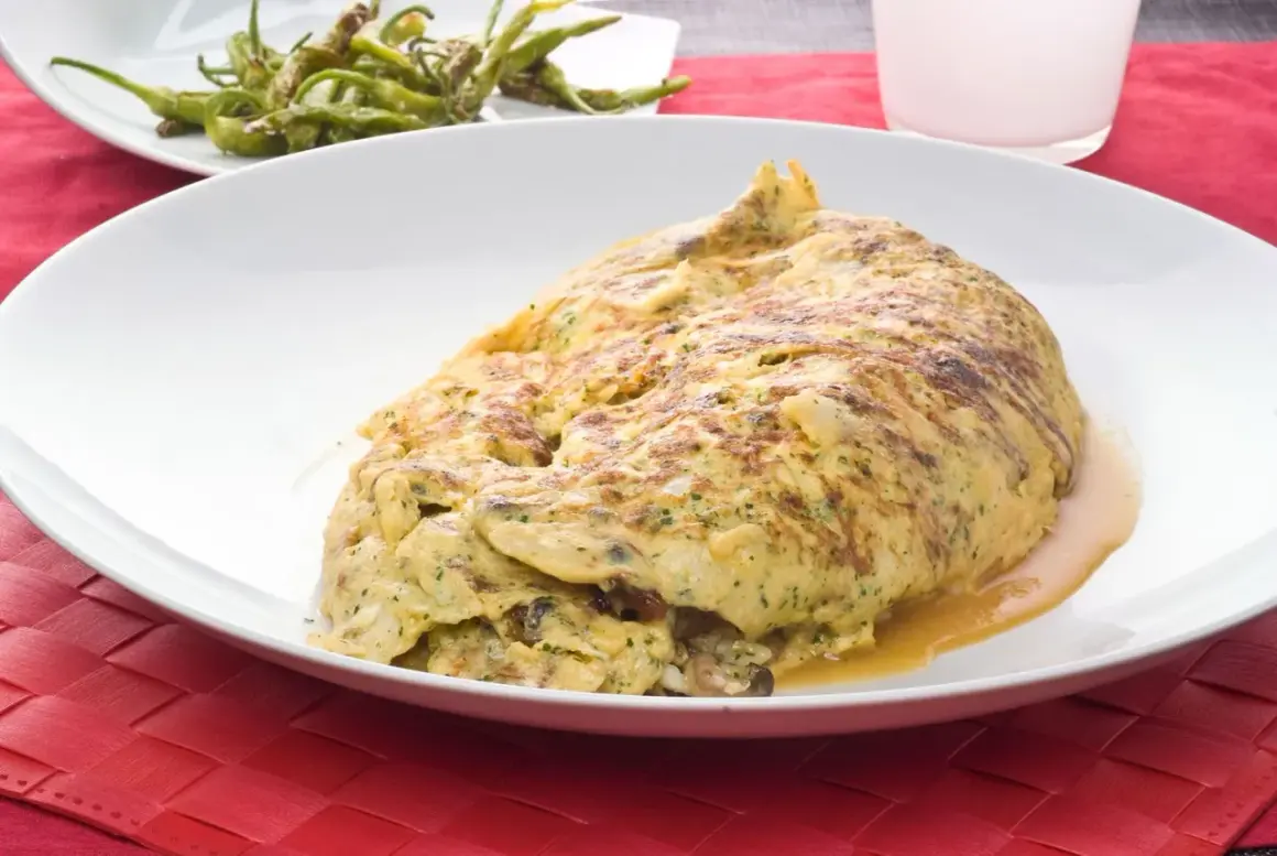 Tortilla de bacalao vasca, esponjosa y dorada, servida en plato blanco sobre mantel rojo.