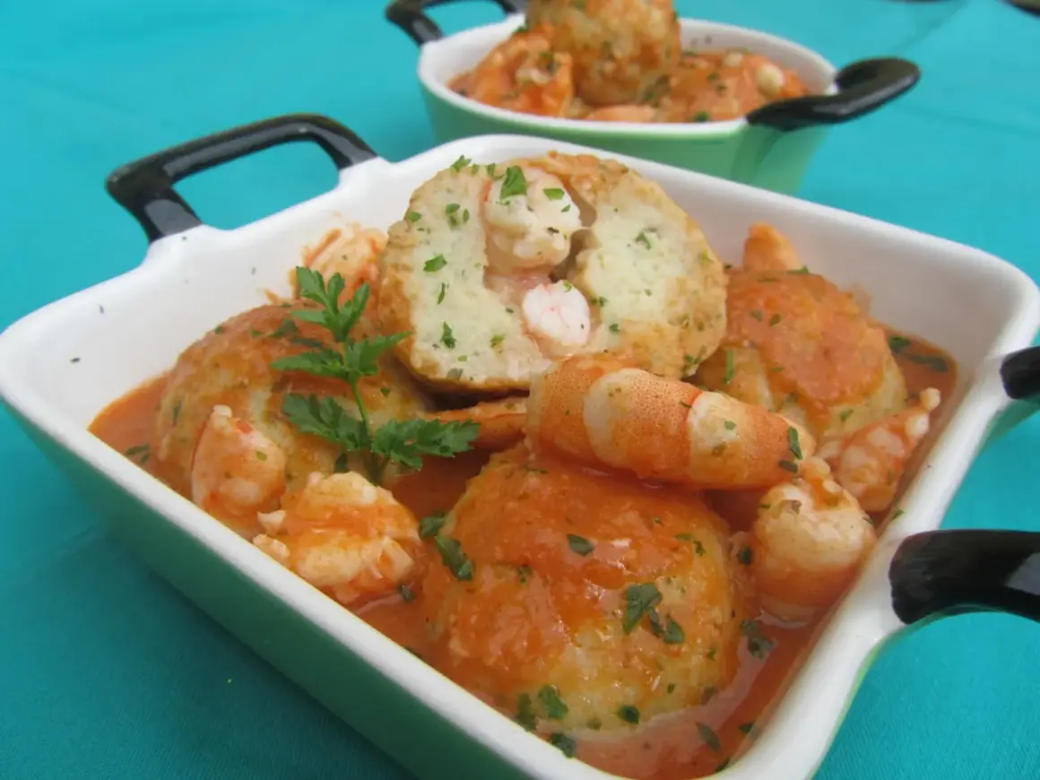 Albondigas de rape con gambas en salsa, servidas en cazuelas verdes y blancas, decoradas con perejil fresco.