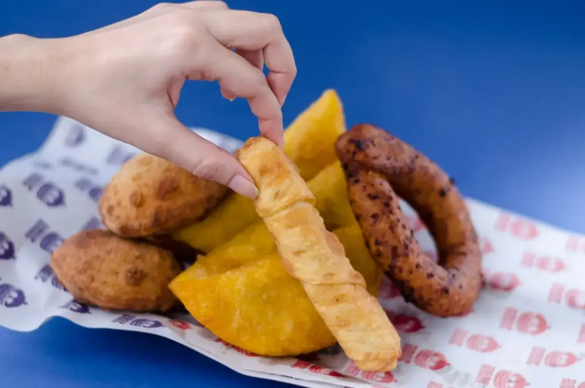 Mano toma un tequeño, un bocado delicioso que nos recuerda de donde son los tequeños, junto a empanadas y chorizo.