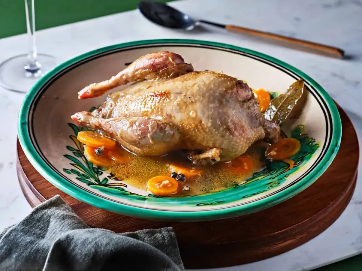 Perdiz a la toledana servida en plato decorado con rodajas de zanahoria y especias.
