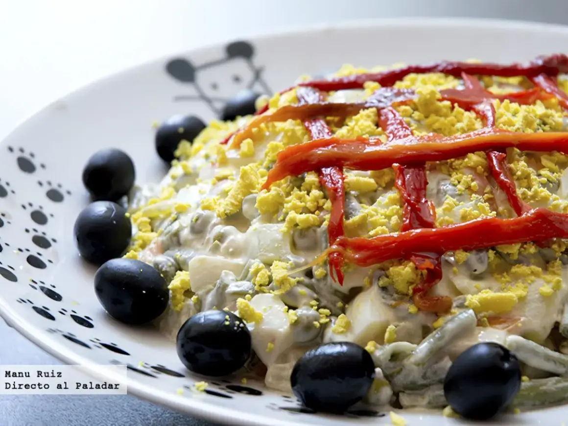 Ensaladilla rusa Thermomix cremosa, decorada con pimientos rojos y aceitunas negras. ¡Perfecta para cualquier ocasión!