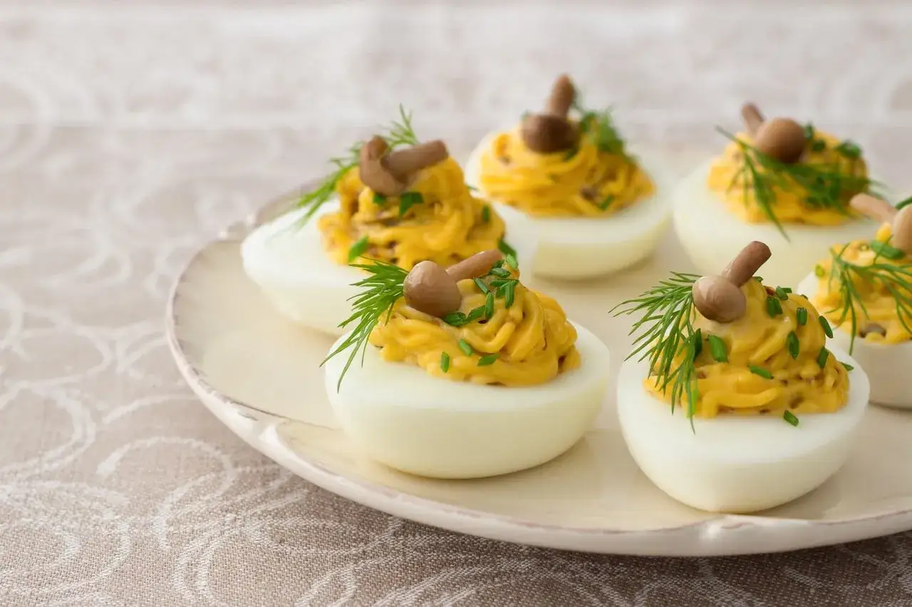Huevos rellenos decorados con champiñones y eneldo, una deliciosa opción para tus recetas con huevos.