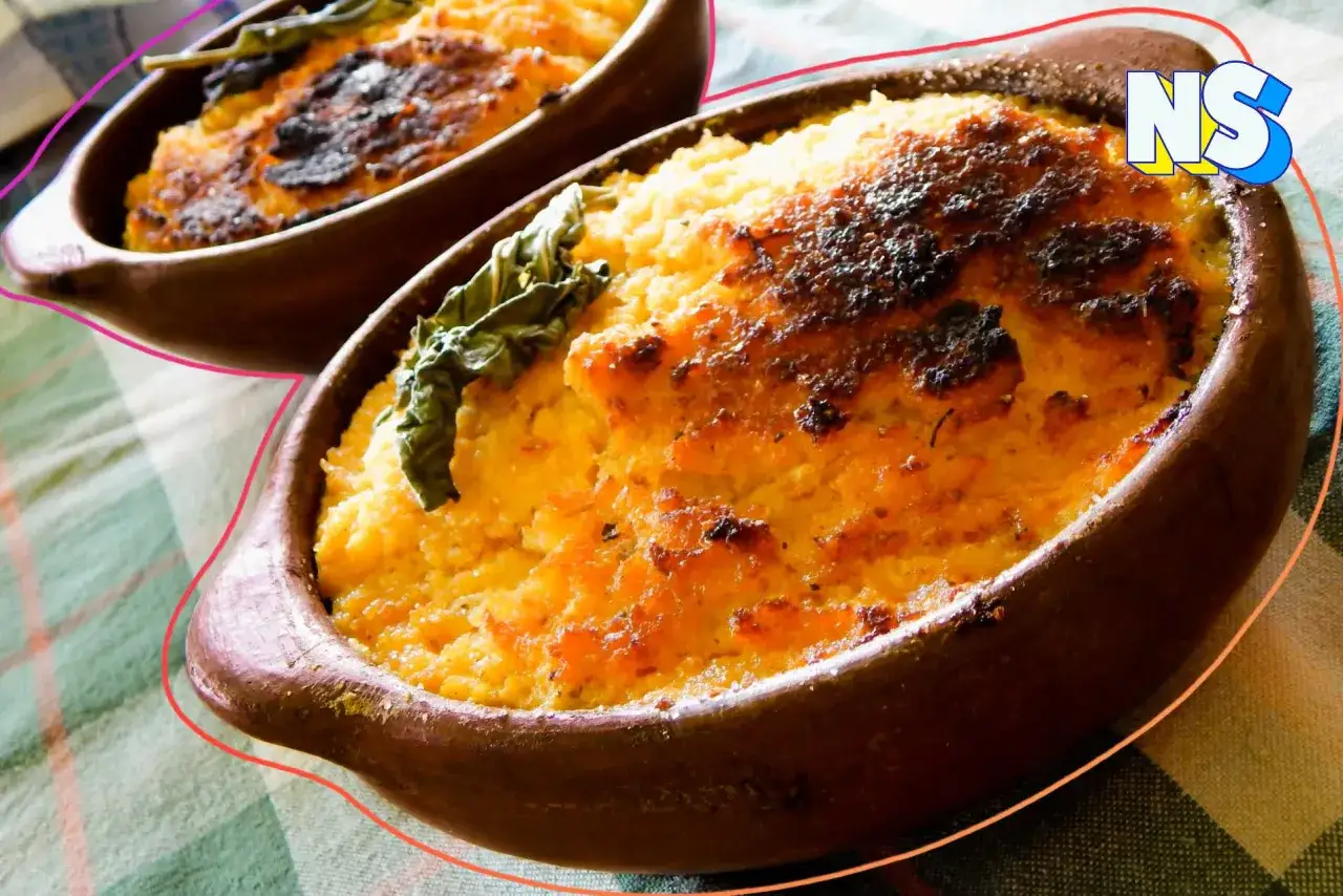 Dos cazuelas de barro con pastel de choclo gratinado, decorado con hojas verdes.