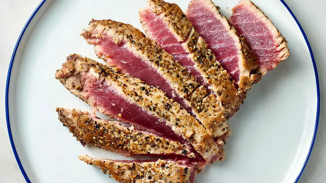 Rodajas de at&uacute;n a la plancha, con un exterior dorado y un interior rosado y jugoso, cubiertas con una mezcla de especias.