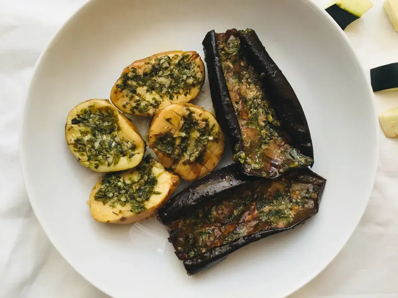 Berenjenas asadas al horno, tiernas y jugosas, con patatas cortadas y aderezadas con hierbas frescas.
