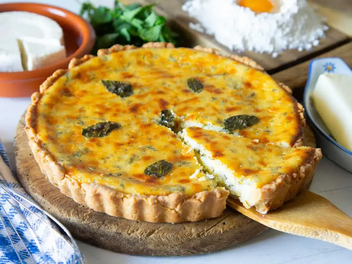 Un delicioso postre típico de Ibiza, una tarta salada con queso fresco y hierbas aromáticas, lista para ser disfrutada.